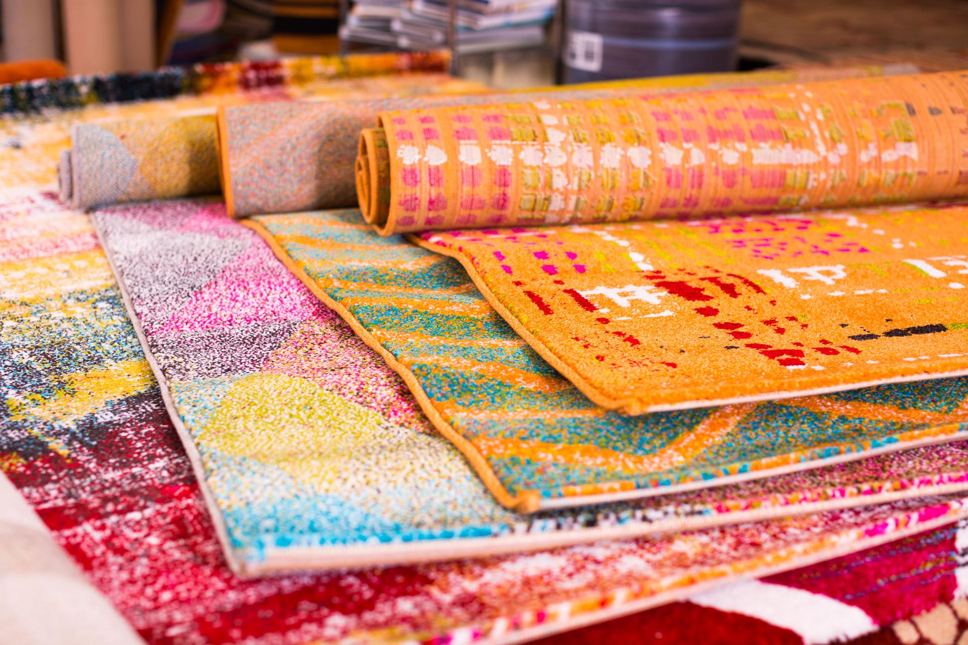 Various colorful wool rugs for sale at store