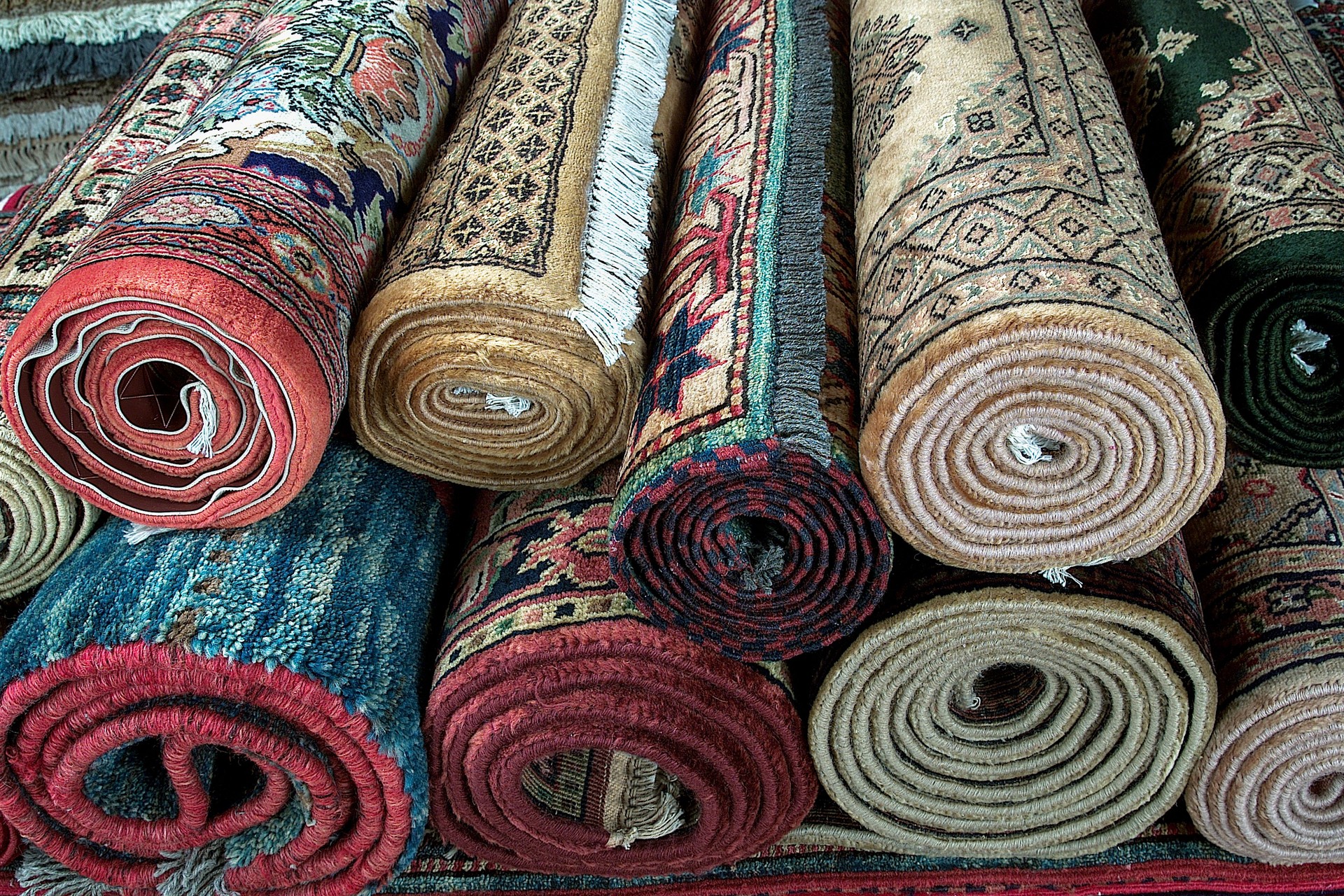Rugs, different Persian style stacked roll rugs, many rolls of assorted rugs