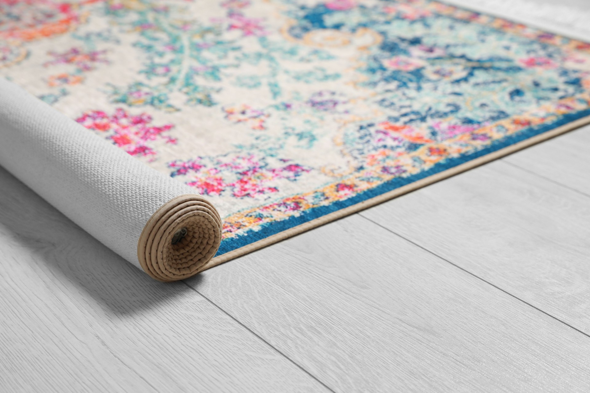 Rolled carpet with beautiful pattern on floor, closeup. Space for text